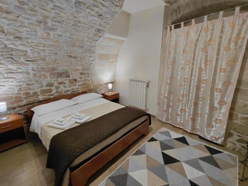 a bedroom with a bed and a stone wall at Le Stanze sul Colle in Palo del Colle