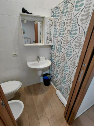 a bathroom with a sink and a toilet and a shower curtain at Le Stanze sul Colle in Palo del Colle