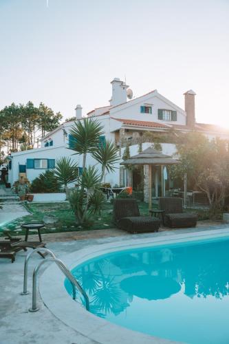 a swimming pool in front of a house at João Jungle in Açafora