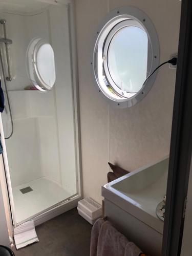 a bathroom with a mirror and a sink and a tub at Mobilhome camping Rivage des Landes in Aureilhan