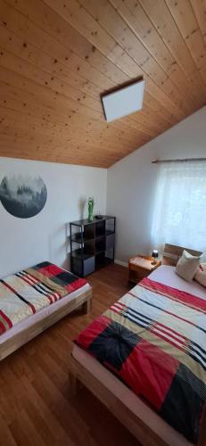 a bedroom with two beds and a wooden ceiling at Donaublick Möhringen in Tuttlingen
