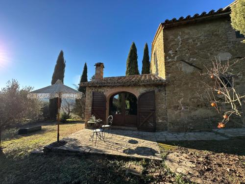 a building with an umbrella in a yard at Villa Amici Apartment in Fontignano