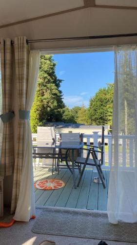 a patio with a table and chairs on a deck at Isle of Wight Caravan in Shanklin