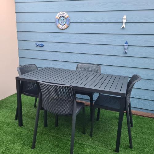 a black table and chairs in front of a garage at Le Pavillon du trou d'eau in La Saline les Bains