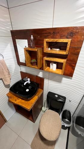 a bathroom with a black toilet and a sink at Morada das Estrelas in Cambará