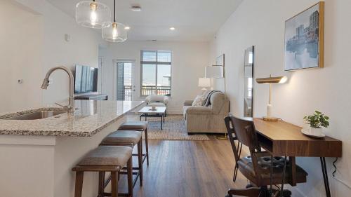 a kitchen and living room with a counter and chairs at Landing Modern 2BD Gym Clubhouse in Longmont