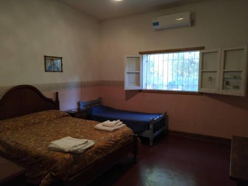 a bedroom with a bed and a window at Casona El Olivo in Villa Krause