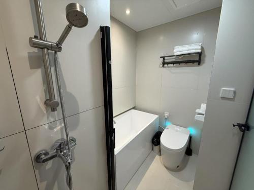 a white bathroom with a shower and a toilet at Shanghai Clivia Hotel in Shanghai