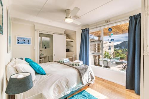 a bedroom with a bed and a large window at The Mermaid's Tail in Pringle Bay
