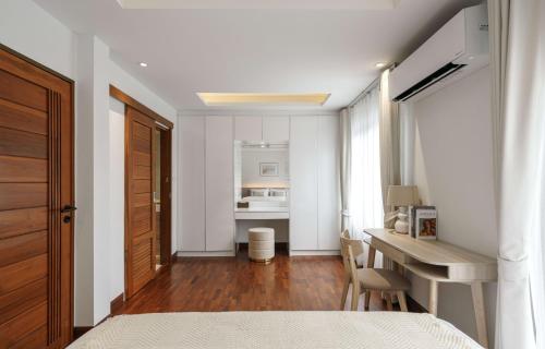 a bedroom with a bed and a desk and a table at Bhumidol Home near Don Muang Airport in Lak Si