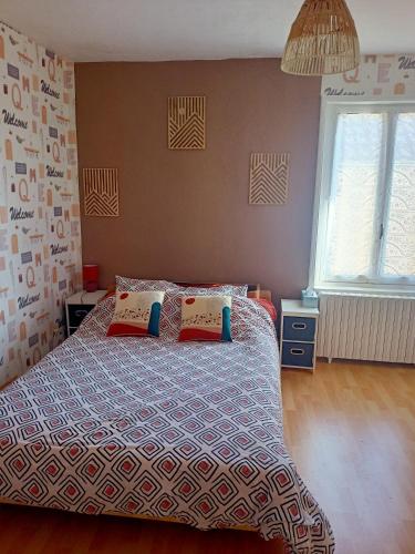 a bedroom with a bed with two pillows on it at Entre Bresse et Jura in Bellevesvre