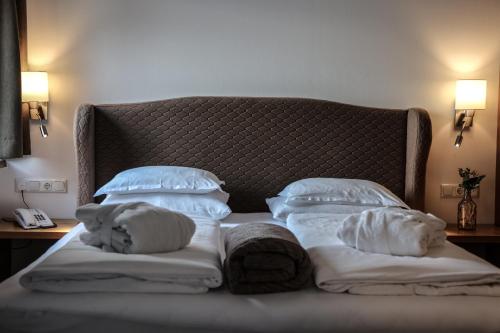 a bed with white blankets and pillows on it at Hotel Geisler Tulfes in Tulfes