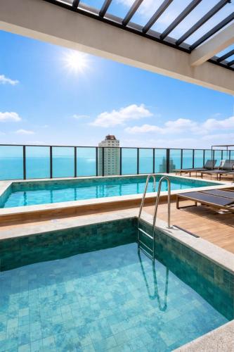 a swimming pool with a view of the ocean at Summerview novo , 2 piscinas e 2 jacuzzis, 2 quartos Novo! in Itapema