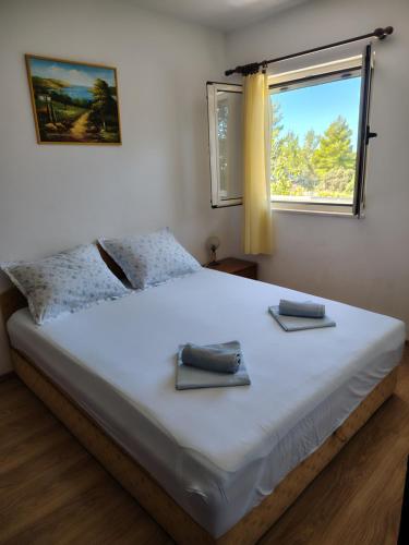 a bedroom with a large white bed with a window at Apartmani Barba Sevid in Sevid