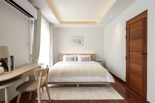 a bedroom with a bed and a desk and a chair at Bhumidol Home near Don Muang Airport in Lak Si