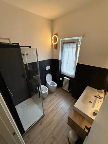 a bathroom with a toilet and a sink and a mirror at Luisella house in Isola Sacra