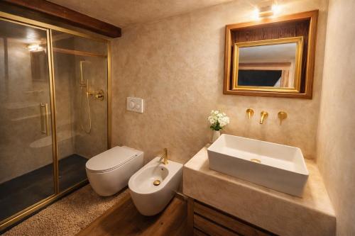 a bathroom with a sink and a toilet and a shower at Casalpina Cozy chalet in Gressoney-la-Trinité