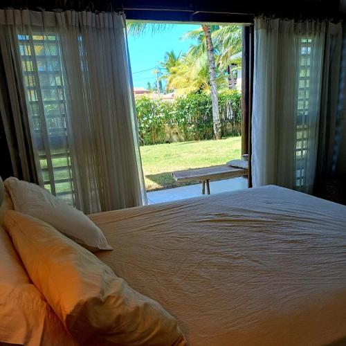 a bedroom with a large bed and a large window at Casa meravigliosa vicino alla spiaggia con grande piscina e giardino in Beberibe