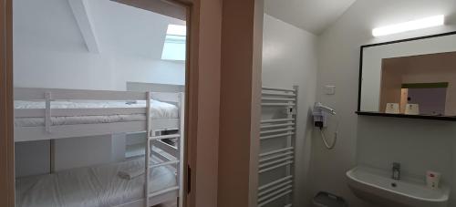 a bathroom with a shower and a sink and a mirror at Hôtel Le P'tit Monde in Montignac