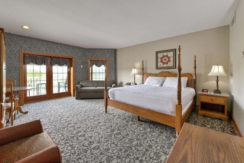a large bedroom with a bed and a couch at Carlisle Inn in Sugarcreek