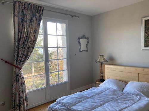 a bedroom with a bed and a large window at Domaine des Rochaules in Valoreille