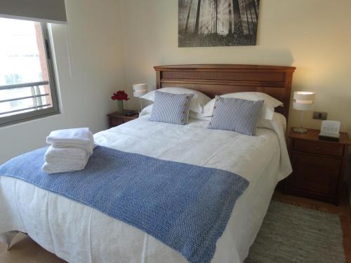 1 dormitorio con 1 cama con 2 toallas en Departamento Parque de los Reyes, en Santiago