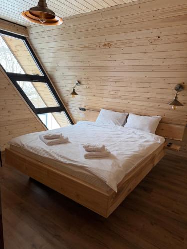 a bedroom with a bed with two towels on it at Refugiul din Deal in Mărgău