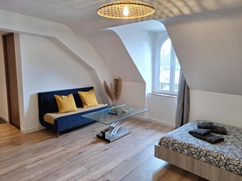 a living room with a blue couch and a glass table at Faubourg des voyageurs 7 - T2 climatisé 4 personnes - proche axe autoroute et gare in Saran
