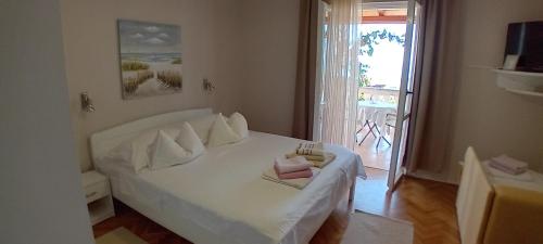 a bedroom with a white bed with towels on it at Apartments Panorama view Zeljko Scerbe in Rab