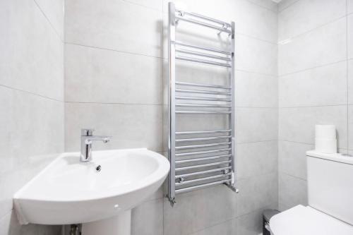 a white bathroom with a sink and a toilet at Spacious 2br Gem - Close To Clapham Junction in London