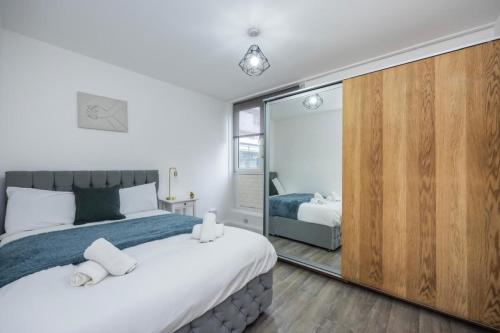 a bedroom with a large bed and a mirror at Spacious 2br Gem - Close To Clapham Junction in London