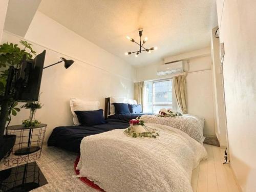 a bedroom with two beds and a tv at BEST LOCATED SHINJUKU CENTRAL Full-Furnished APARTMENT 3minWalk to Station2 in Tokyo
