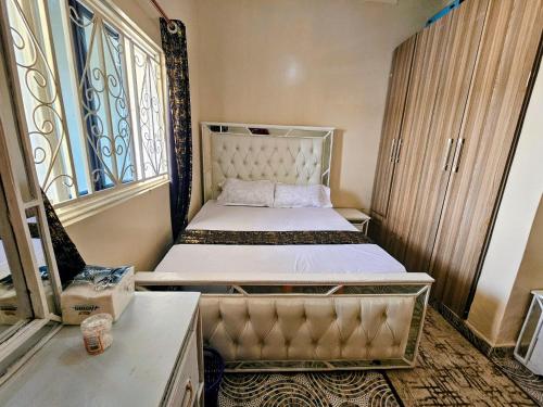 a small room with two beds and a window at Deripacs Homes in Lodwar