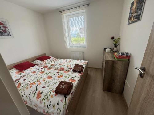 a small bedroom with a bed and a window at Apartmán Adam in Dolní Moravice