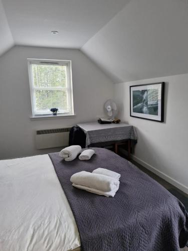 a bedroom with a bed with towels on it at Cosy Private Flat - Pet Friendly in Kirriemuir