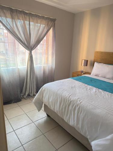 a bedroom with a bed and a window at Kloppenheim Sectional Lifestyle Complex in Ellisras