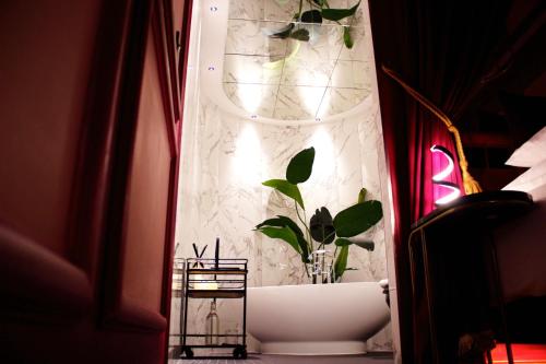 a bathroom with a tub with a plant in it at Impossible Motel in York