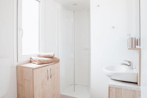 a white bathroom with a sink and a mirror at House no 4 in Pakoštane