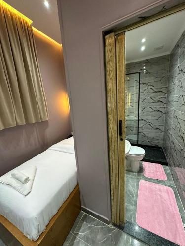 a bedroom with a bed and a bathroom with a toilet at KASTELLO hotel in Cairo