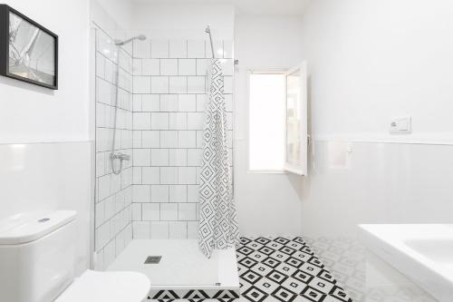 a white bathroom with a shower and a toilet at CASA MILA SV19 guesthouse in Alicante