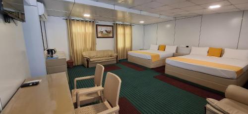 a room with two beds and a table and chairs at Bhagya Resort Limited in Nikawatawana
