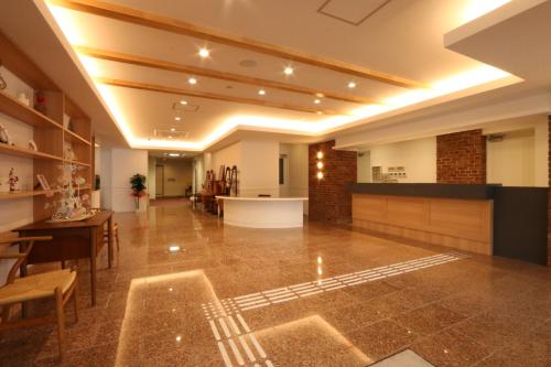 a large room with a lobby with a table and chairs at Amakusa Santacoming Hotel in Amakusa