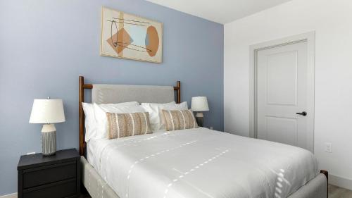 a bedroom with a white bed and a blue wall at Landing Stunning 2BD in Corinth in Denton