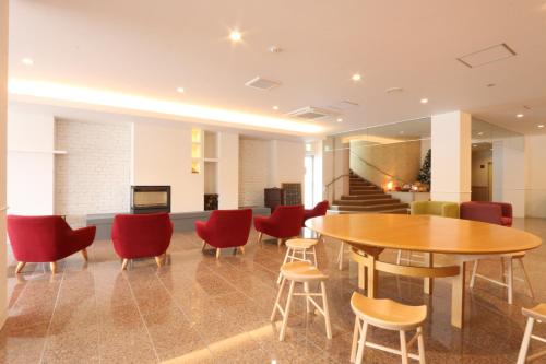 a lobby with a table and chairs and stairs at Amakusa Santacoming Hotel in Amakusa
