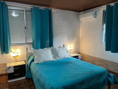 a bedroom with a blue bed with blue curtains at La Dorada in Barra del Chuy