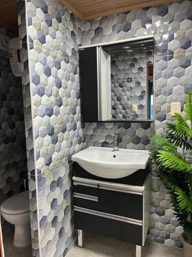 a bathroom with a sink and a mirror and a toilet at La Dorada in Barra del Chuy