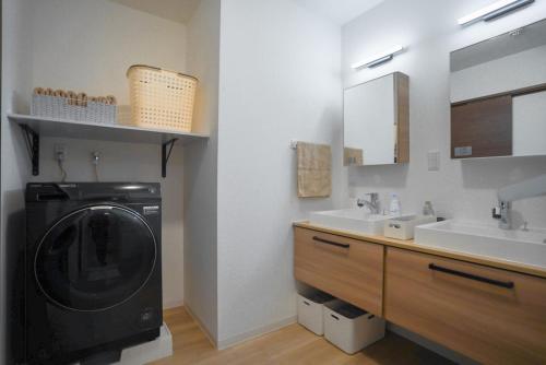 a bathroom with a washing machine and a sink at Laon Inn Plus Miyakojima in Miyako-jima