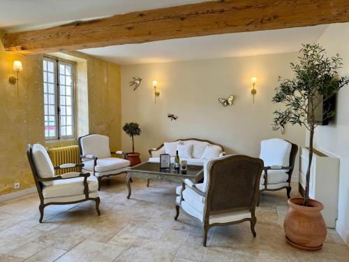a living room with white chairs and a table at Hotel Du Midi in Visan