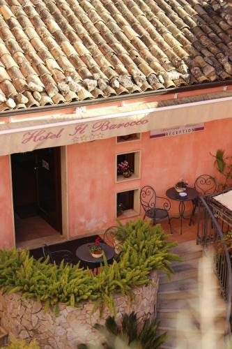 a balcony of a building with tables and chairs at Hotel Il Barocco in Ragusa