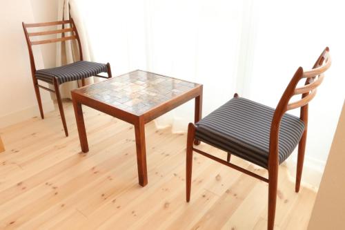 two chairs and a table with a glass top at Amakusa Santacoming Hotel in Amakusa